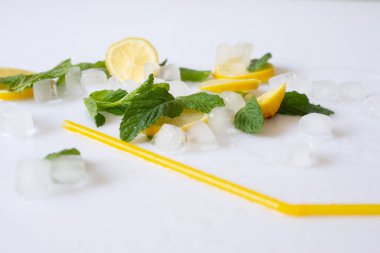 Beyaz arka planda buz, limon ve nane ile serinletici yaz kokteyli döküldü..