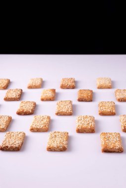 Beyaz arka planda susam tohumlu kurabiye mozaiği.