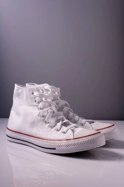 Fehér új cipő piros csík szürke háttér — Stock Fotó