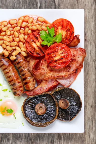 Повний англійський сніданок з беконом, ковбаса, яйце, боби і грибами — стокове фото