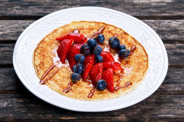 Taze altın çilek, yaban mersini ve çikolata ile krep.