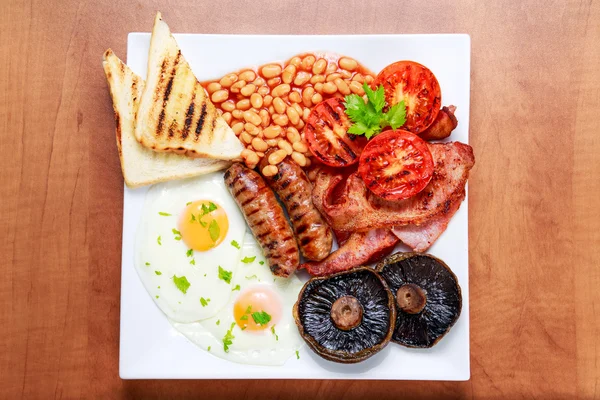 Pequeno-almoço inglês completo com bacon, salsicha, ovo, feijão e cogumelos — Fotografia de Stock