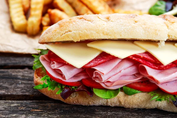 Sanduíche com alface, fatias de tomate fresco, salame, zumbido e queijo — Fotografia de Stock