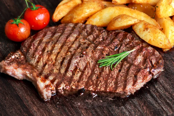 Grilovaný hovězí steak. s brambory a rajčaty — Stock fotografie