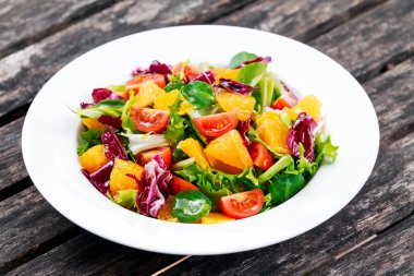 Ahşap masa üzerinde taze turuncu, sebze salatası.