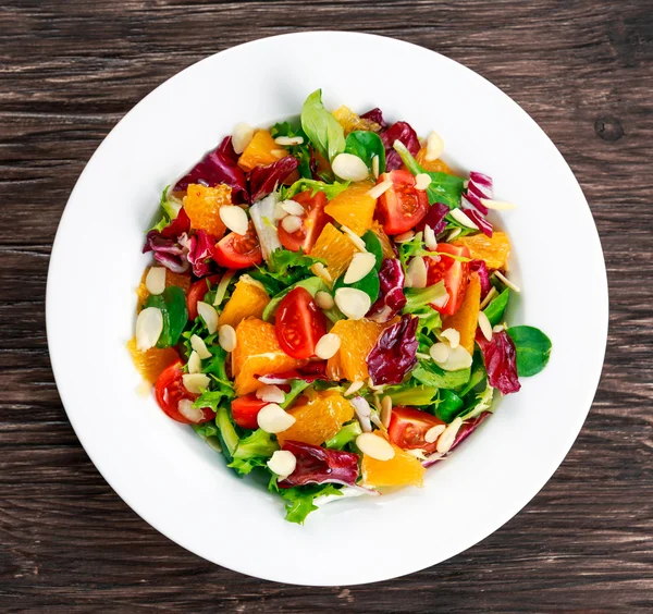 Laranja fresca, salada de legumes em mesa de madeira . — Fotografia de Stock