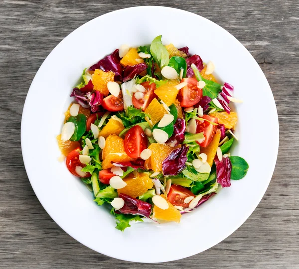 Laranja fresca, salada de legumes de morango. na mesa de madeira . — Fotografia de Stock