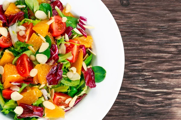 Laranja fresca, salada de legumes em mesa de madeira . — Fotografia de Stock