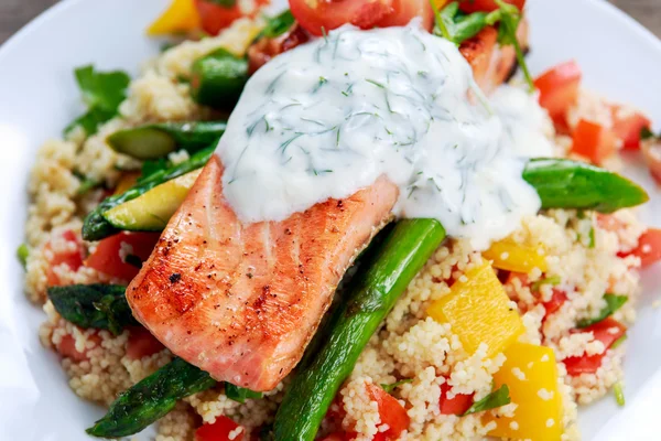 Pan fried Salmon with tender asparagus, courgette served on couscous mixed with sweet tomato, yellow pepper, greek yogurt with dill — Stock Photo, Image