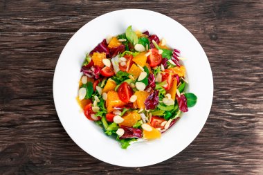 Ahşap masa üzerinde taze turuncu, sebze salatası.