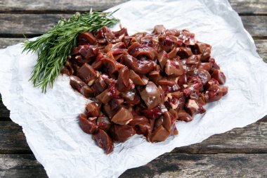 Rosemary ile dekore edilmiş buruşuk kağıt üzerinde ham böbrekler.