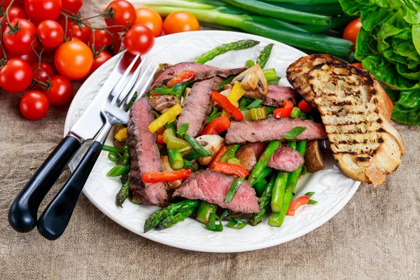 접시에 볶은 야채와 함께 구운된 스테이크. — 스톡 사진