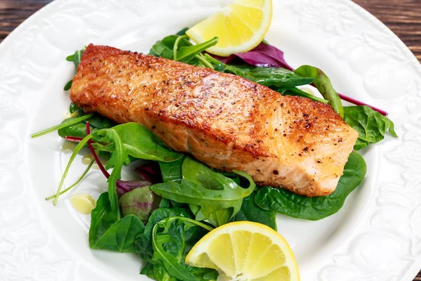 Fried salmon fillet served with vegetables and lemon — Stock Photo, Image