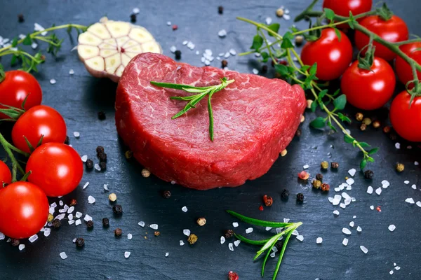 Färsk rå biff Mignon, med salt, pepparkorn, timjan, tomat. — Stockfoto