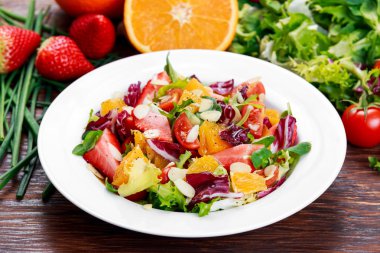 Ahşap masa üzerinde taze turuncu, sebze salatası.