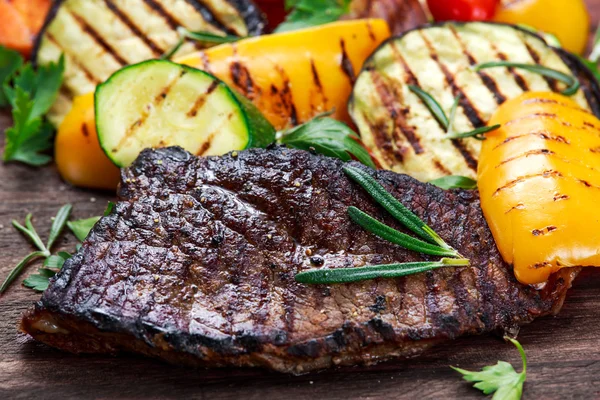 Beef steak and Grilled vegetables. On cutting dark board — Stock Photo, Image