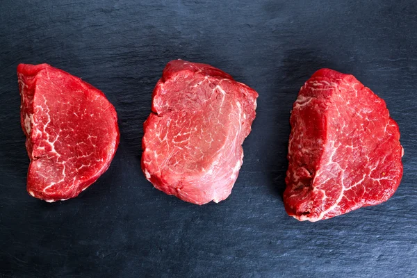 Čerstvé syrové hovězí steak Mignon na tmavě modré pozadí, — Stock fotografie