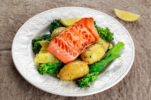 Pan fried Salmon Served with potatoes and tenderstem broccoli. — Stock Photo, Image