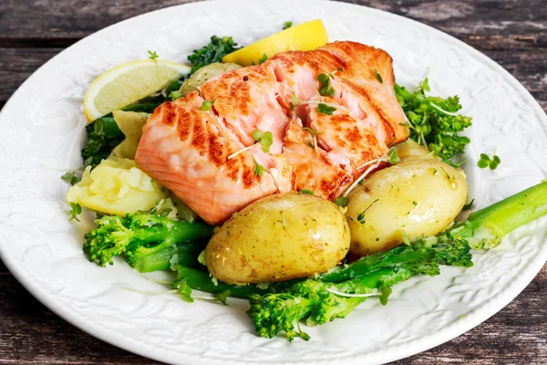 Pan fried Salmon Served with potatoes and tenderstem broccoli. Royalty Free Stock Images