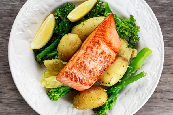 Pan fried Salmon Served with potatoes and tenderstem broccoli. — Stock Photo, Image