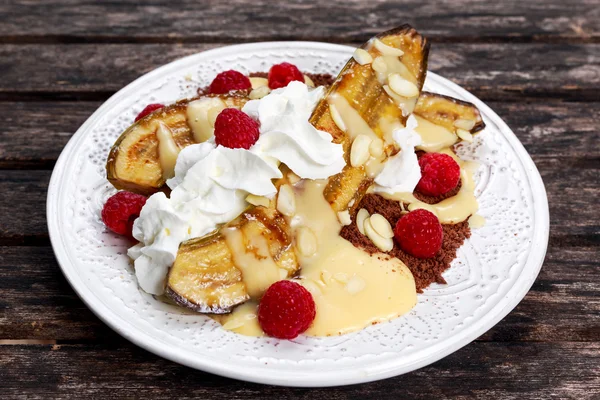 Postre de plátano con frambuesas, menta bajo crema batida — Foto de Stock