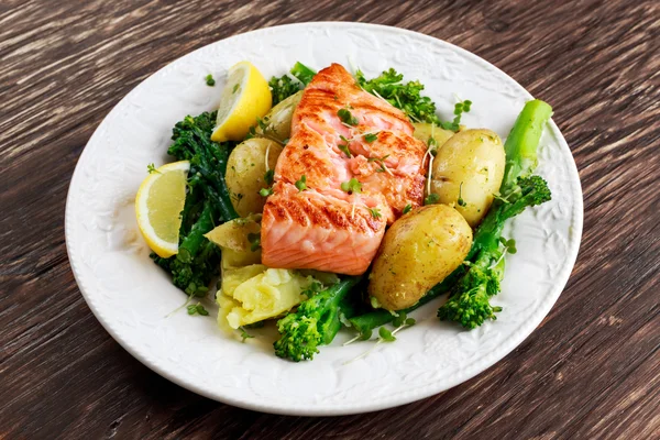 Pan fried Salmon Served with potatoes and tenderstem broccoli. — Stock Photo, Image