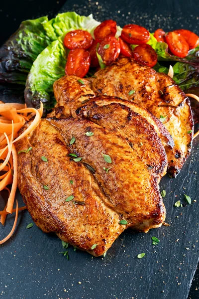 Bistecche al petto di pollo alla griglia con pomodorini, carote, foglie di insalata . — Foto Stock