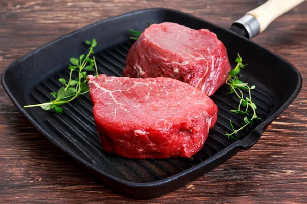 Fresh Raw Beef steak Mignon with thyme on grilled pan — Stock Photo, Image