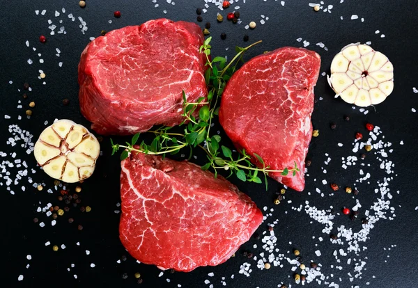 Carne fresca de res cruda Mignon, con sal, granos de pimienta, tomillo, ajo . — Foto de Stock