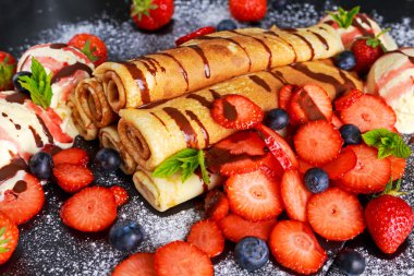 Tatlı krep nutella, çilek, yaban mersini ve dondurma ile haddelenmiş