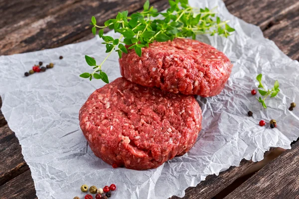 Home Hecho a mano carne de res picada cruda hamburguesas en papel revuelto — Foto de Stock