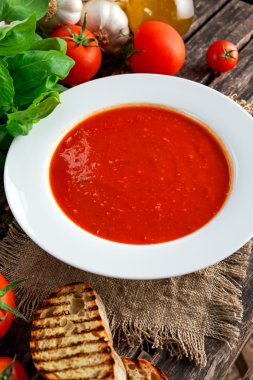 Yumuşak ve tatlı domates çorbası, fesleğen ile terbiyeli sarımsak.