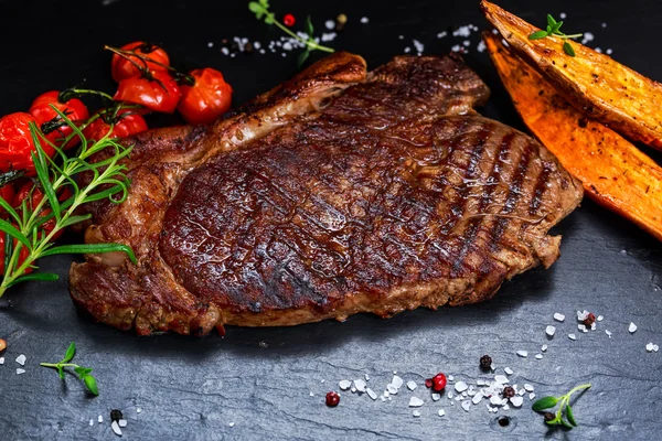 Grilovaný hovězí Steak na modrém pozadí kamene, se zeleninou. — Stock fotografie