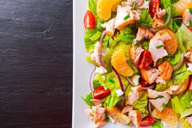 Tatlım, domates, soğan, mandarin taze turuncu somon salata. sağlıklı