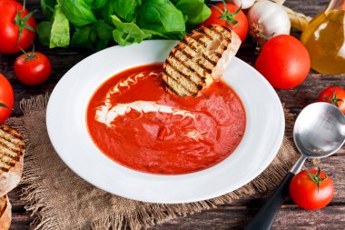 Yumuşak ve tatlı domates çorbası, fesleğen ile terbiyeli sarımsak.