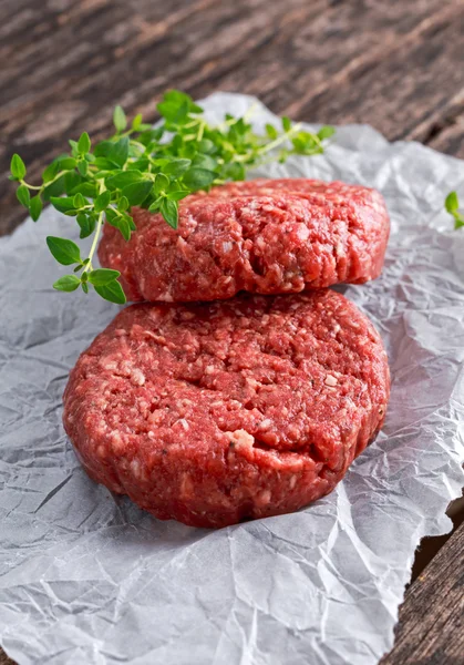 Home Hecho a mano carne de res picada cruda hamburguesas en papel revuelto — Foto de Stock