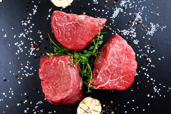 Carne fresca de res cruda Mignon, con sal, granos de pimienta, tomillo, ajo . — Foto de Stock