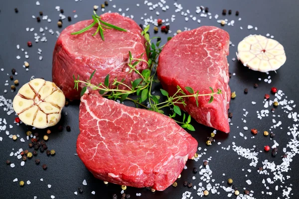 Carne fresca de res cruda Mignon, con sal, granos de pimienta, tomillo, ajo . — Foto de Stock