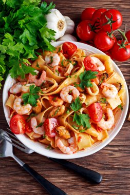 Karides, kalamar, midye, domates ve otlar ile lezzetli Pappardelle makarna.