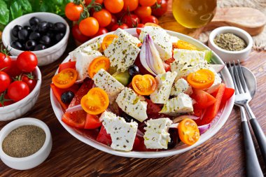 Yunan salata taze tatlı biber, kırmızı soğan, portakal kiraz domates, salatalık, Siyah Zeytin ve beyaz peynir ile drizzled ahşap masa üzerinde sızma zeytinyağı