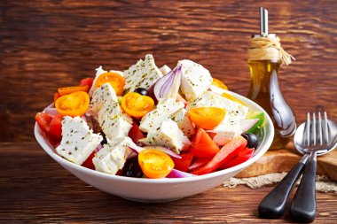 Yunan salata taze tatlı biber, kırmızı soğan, portakal kiraz domates, salatalık, Siyah Zeytin ve beyaz peynir ile drizzled ahşap masa üzerinde sızma zeytinyağı