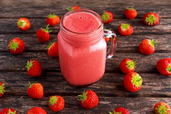 Jordgubbe smoothie i burk glas på träbord. hälsosam mat koncept för frukost eller mellanmål. — Stockfoto