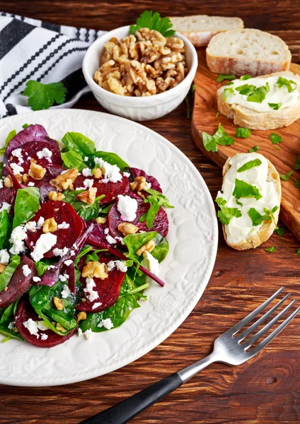 Здоровый свекольный салат со свежим сладким детским шпинатом, капустным салатом, орехами, сыром фета и тостами — стоковое фото