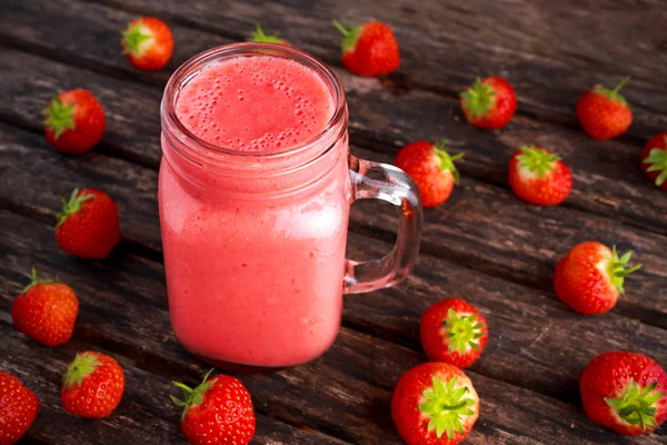 Jordgubbe smoothie i burk glas på träbord. hälsosam mat koncept för frukost eller mellanmål. — Stockfoto