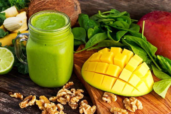 Friska gröna nå vitaminer Smoothie med baby leaf spenat, grönkål, mango, banan, lime, valnöt och kokos vatten. — Stockfoto