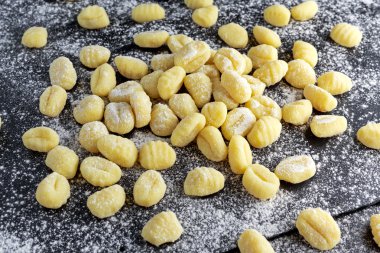 Pişmemiş ev yapımı gnocchi unlu tahta kesme taş.