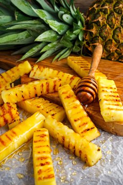 Buruşuk kağıt üzerinde bal ile ızgara ananas dilimleri. Seçilen odak