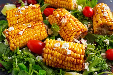 Lezzetli fırında Mısır pişmiş beyaz peynir, kırmızı biber, limon, sebze ile.