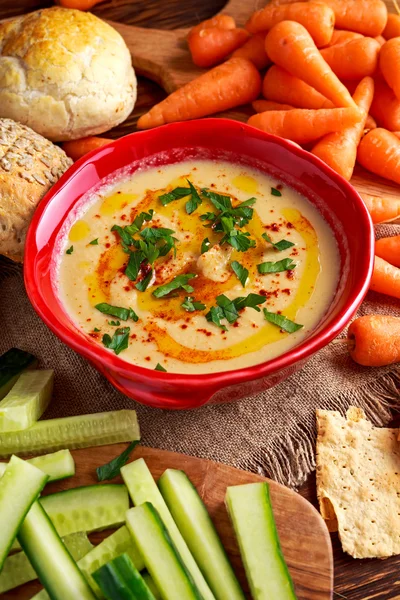 Classic Homemade hummus with olive oil, carrots, cucumber, flatbread, parsley.