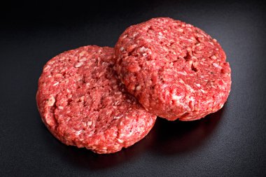 Eve el yapımı çiğ kıyılmış sığır eti biftek hamburger kara tahta üzerinde